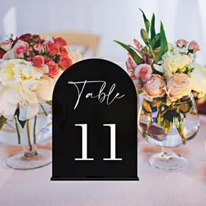Acrylic wedding table number sign with elegant floral decor for event reception setup.