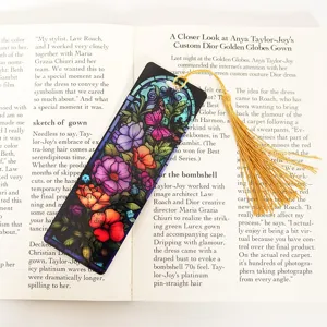 Acrylic stained glass bookmark with floral butterfly design and golden tassel for reading.