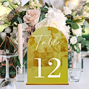 Gold acrylic table number sign detail view, elegant wedding reception table decor setting.