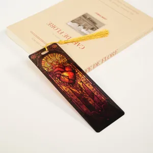 Close-up view of an acrylic stained glass anatomical heart bookmark with a golden tassel.