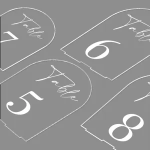 Clear acrylic arch table number signs with white printed text for wedding reception decoration.