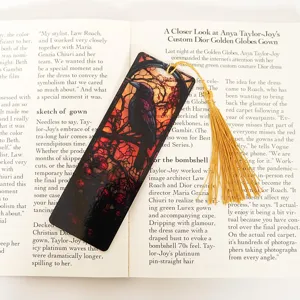 Stained glass raven bookmark detail shot with golden tassel on open book page background