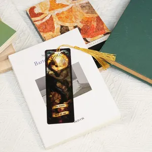 Translucent acrylic bookmark with dragon design and gold tassel, detailed product view.