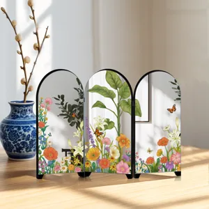 Desktop arched folding mirror screen detail featuring delicate floral and botanical art prints.