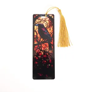 Close-up detail of the stained glass crow bookmark with a hanging golden tassel accent.