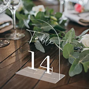 Clear acrylic arch table number sign detail view for wedding party reception table decor setup.