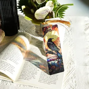Translucent stained glass crow bookmark with elegant gold tassel, detailed reading accessory.