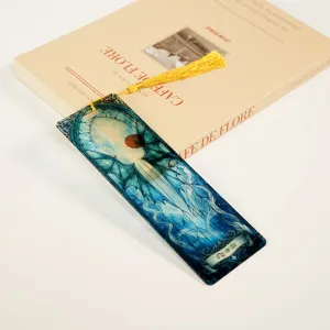 Detailed close-up of acrylic dragon stained glass bookmark with elegant yellow tassel.