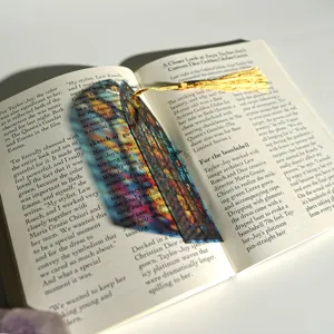 Creative colorful translucent acrylic bookmark with golden tassel and light refraction.