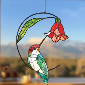 Detailed shot of stained glass hummingbird suncatcher with metal frame and floral design.