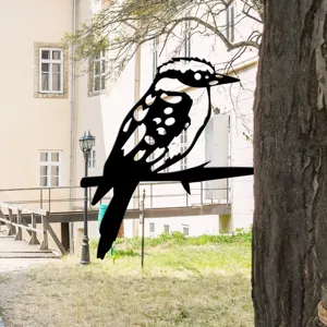 Black metal bird silhouette garden stake, outdoor tree branch decoration detail view