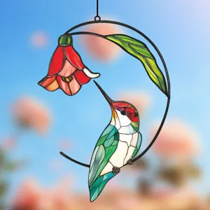 Stained glass hummingbird hanging ornament with red flower and crescent metal frame detail.