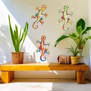 Colorful metal gecko wall decor detail showing vibrant hand-painted patterns on white wall.