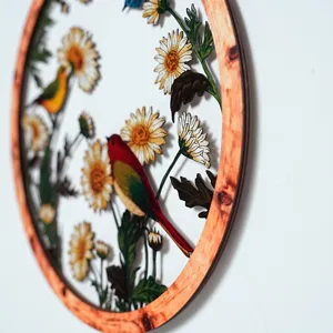 Close-up view of the exquisite wooden round wall hanging with metal floral and bird details.