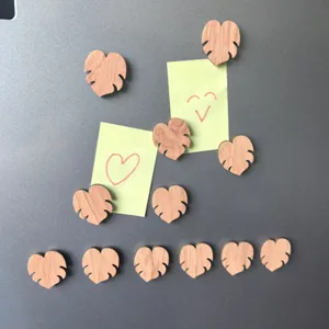 Wooden magnetic fridge sticker detail showing heart shape holding notes securely on metal surface.