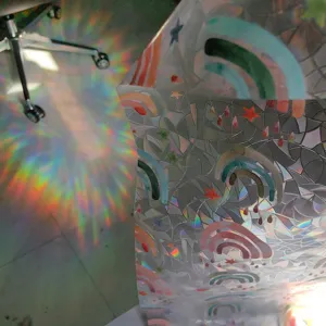 Close-up detail of rainbow window film showing stunning holographic prism light reflection effects.