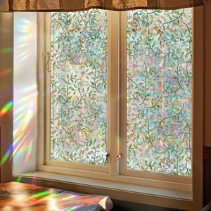 Close-up of decorative window film featuring green leaves and stunning rainbow prism view.