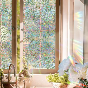Detailed view of window film showing vibrant rainbow prism effect and green leaf botanical pattern.