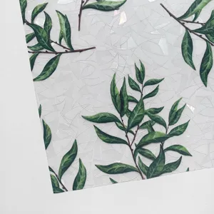 Detail view of static window film with green leaf pattern and rainbow prism glass sticker.