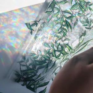 Detailed view of green leaves window film, prismatic rainbow glass sticker for home decor.