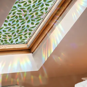 Close-up view of a green leaf window film casting rainbow light on the attic window.
