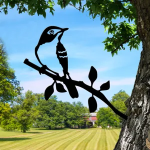 Metal bird tree insert detail showing garden decorative silhouette art outdoors on trunk.