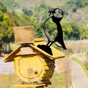 Metal garden stake featuring a black bird silhouette on a rustic wooden house for yard decor.