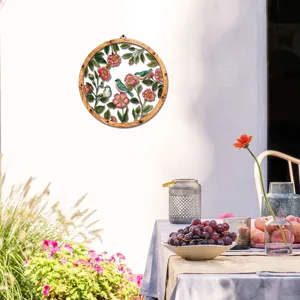 Detail view of round wooden metal wall hanging featuring flower and bird art for home decoration.