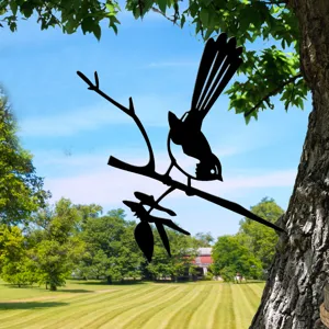 Detailed close-up of metal bird garden stake decor, showcasing black silhouette art on tree.
