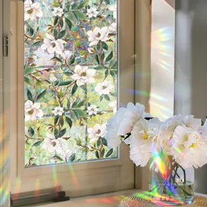 Static cling window film with magnolia flower pattern and iridescent rainbow prism effect.