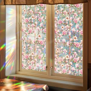 Close-up scene of pink magnolia floral window glass film showing prismatic rainbow light effects.