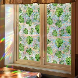Detail view of window glass film with tropical leaves creating vibrant rainbow prism effects.
