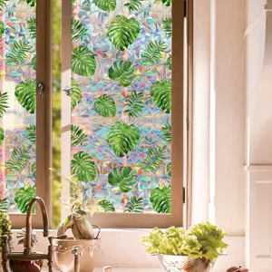 Detail shot of holographic window film with tropical monstera leaves and rainbow prism light.