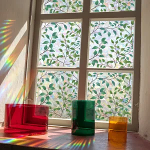 Detailed view of decorative window sticker with green leaves and rainbow prism light effect.