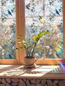 Decorative colorful window film detail showing prism rainbow light effect with bird pattern.