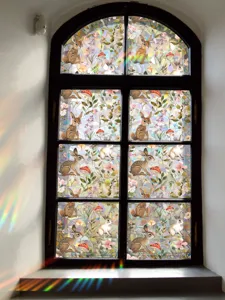 Detailed view of colorful rainbow prism window sticker showing forest animal patterns inside.