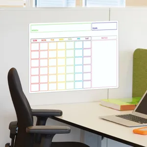 Bürotisch-Szene mit magnetischer Monatskalender-Planertafel und buntem Raster für Notizen.