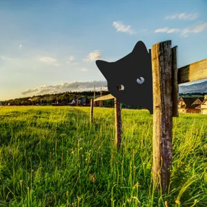 Detail view of a black metal cat silhouette garden stake, outdoor metal decor for yard fence