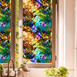 Stained glass window film detail showing vibrant hummingbird and floral pattern, colorful decorative view.