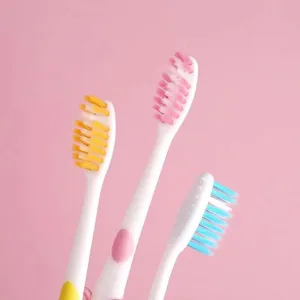 Close-up detail shot of children soft bristle toothbrushes with colorful pastel handles.