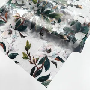 Detailed close-up of holographic window film featuring vibrant magnolia and green leaf patterns.