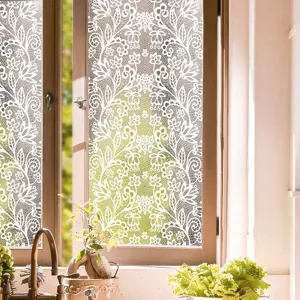 Close-up detail of white lace window film showing elegant translucent floral pattern glass decor.