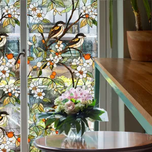Détail du film pour vitre en verre teinté avec motif floral et d'oiseau pour décoration.