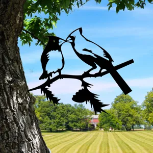 Metal bird silhouette garden ornament detail, black iron tree branch yard stake decor.