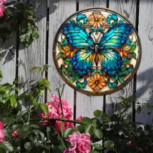 Primer plano del colgante de pared de mariposa de vidrieras redondas en una cerca rústica.