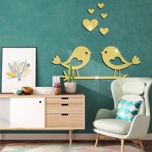 Detailed view of gold acrylic mirror bird and heart wall stickers in a cozy teal living room.