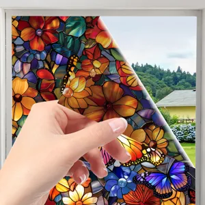 Detailed close-up of stained glass window film with floral butterfly pattern peeling.