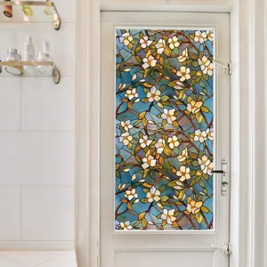 Close-up view of stained glass window film with colorful floral pattern applied on glass door.