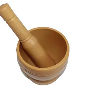 Detail view of wooden mortar and pestle set for kitchen garlic and herb grinding.