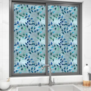 Gedetailleerd overzicht van decoratieve raamfolie met blauw bladerpatroon op glas.